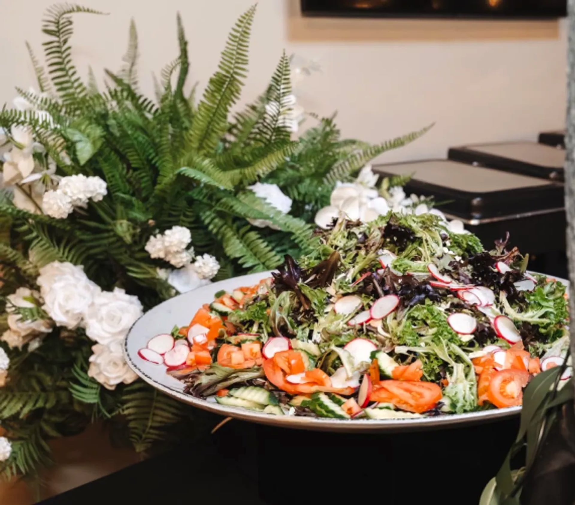 A fresh salad platter with smoked salmon, radish and greens at an Alpha Katering event