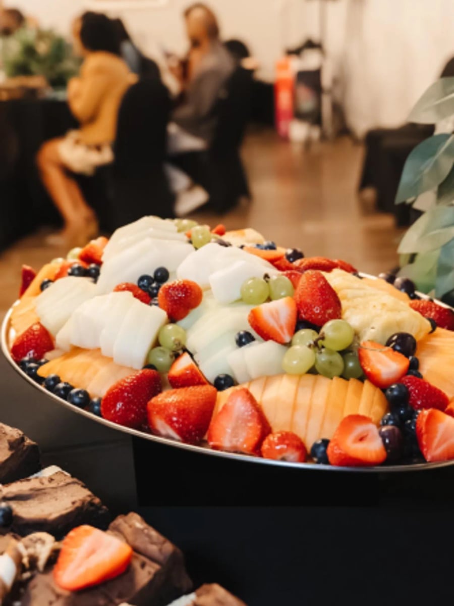 A fruit platter of melon, strawberries and grapes at an event
