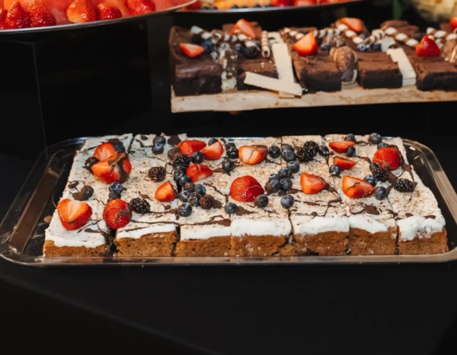 A spread of dessert squares topped with fresh berries